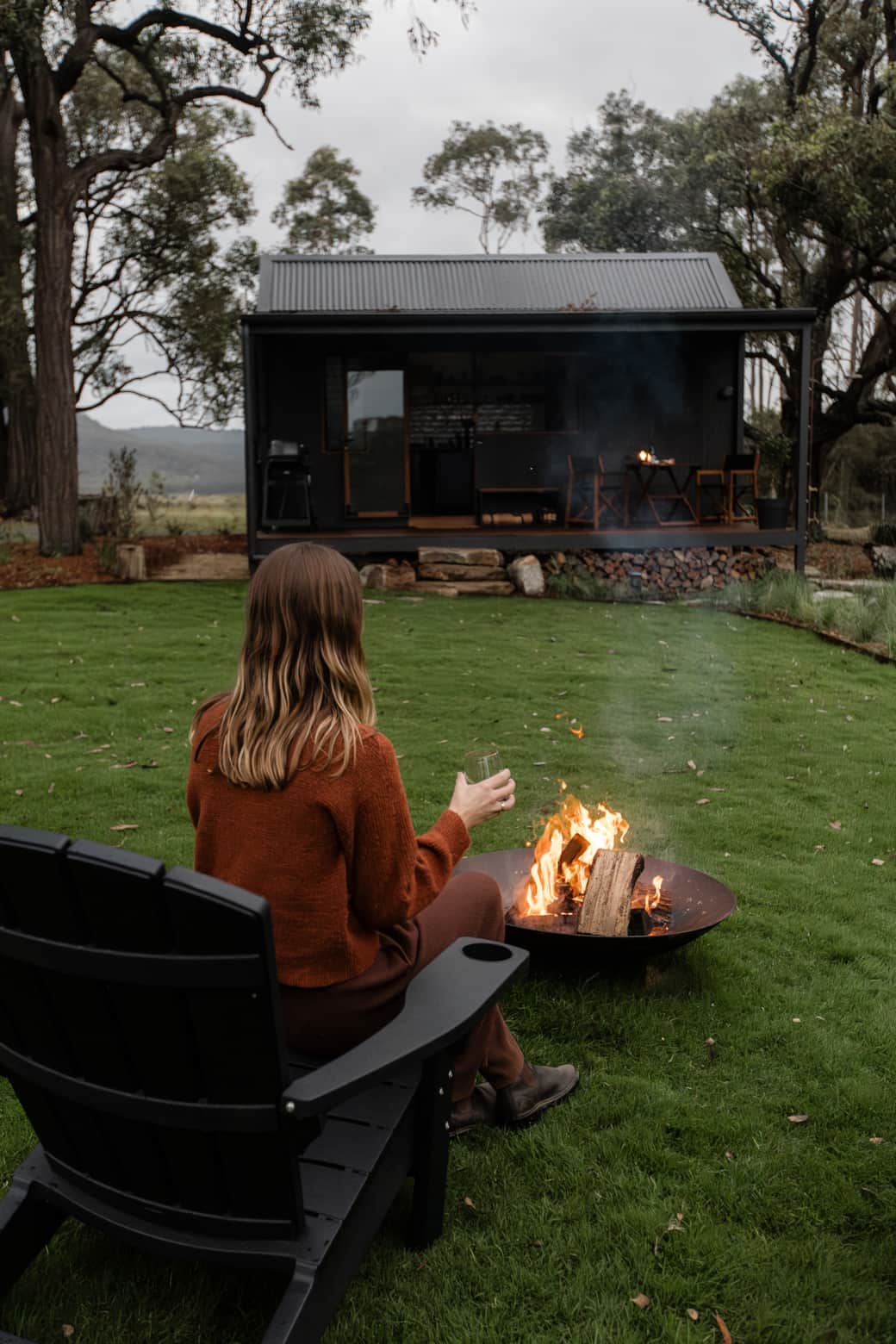 Enjoying a glass of wine beside the fire at Pepperbark Cabin