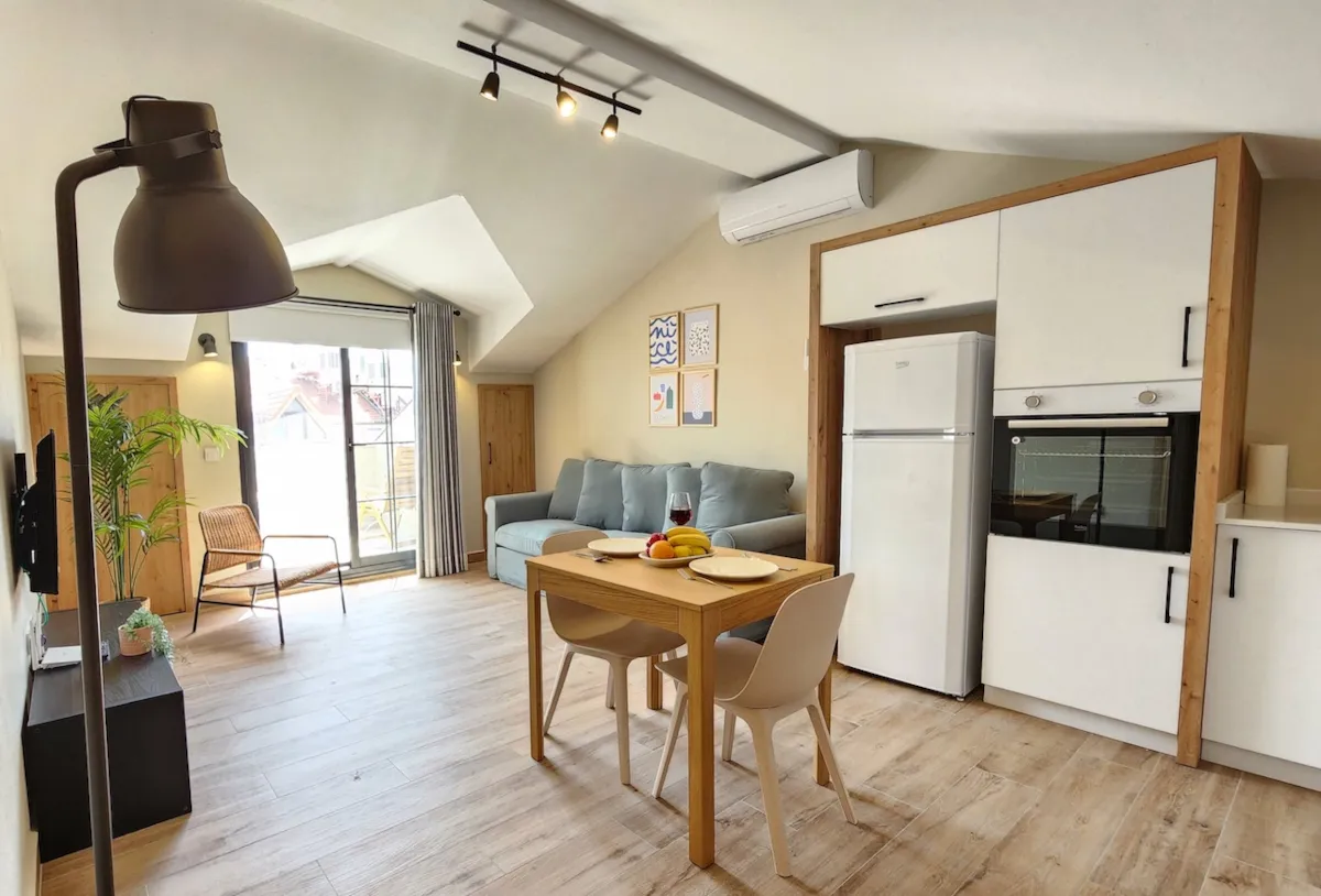 Living area with a sofa, dining table, and kitchen appliances in Apart Guney 010, Gocek.
