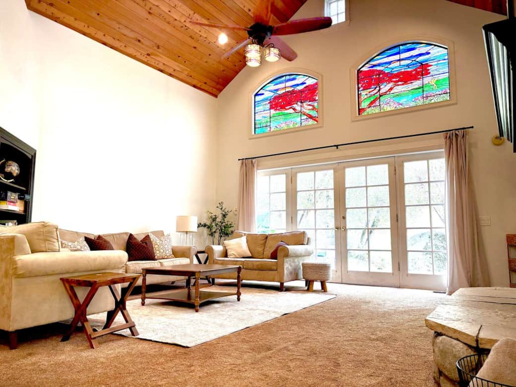 The open-concept living area features dramatic two-story ceilings, comfortable seating, and expansive windows that bring the beauty of the outdoors inside. (2 single foldable rollaway beds available in the bedroom closet.) The open-concept living area features dramatic two-story ceilings, comfortable seating, and expansive windows that bring the beauty of the outdoors inside. (2 single foldable rollaway beds available in the bedroom closet.)