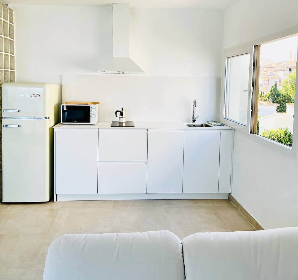 Fully equipped kitchen with fridge, microwave, stovetop, toaster, espresso maker, and dishwasher