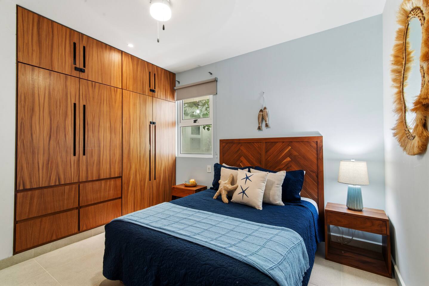 El Dormitorio 2 ofrece una cama queen, baño en suite, entrada privada con cerradura opcional, Smart TV, aire acondicionado, ventilador de techo, armario completo y persianas que oscurecen la habitación. Los interruptores y enchufes junto a la cama hacen que la iluminación y la carga sean convenientes.