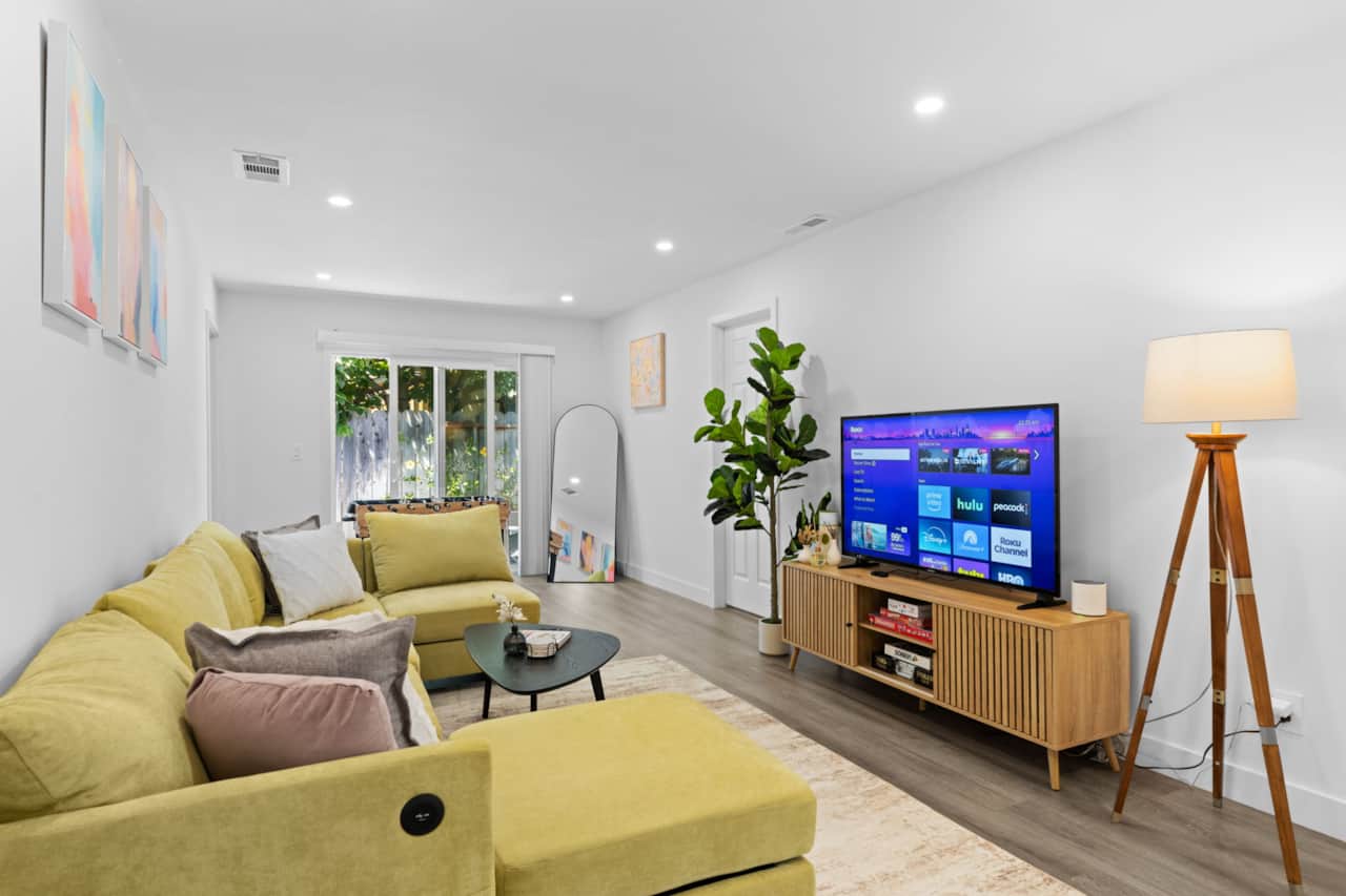 Bright, modern living room with a cozy sectional, stylish decor, smart TV, board games and foosball 