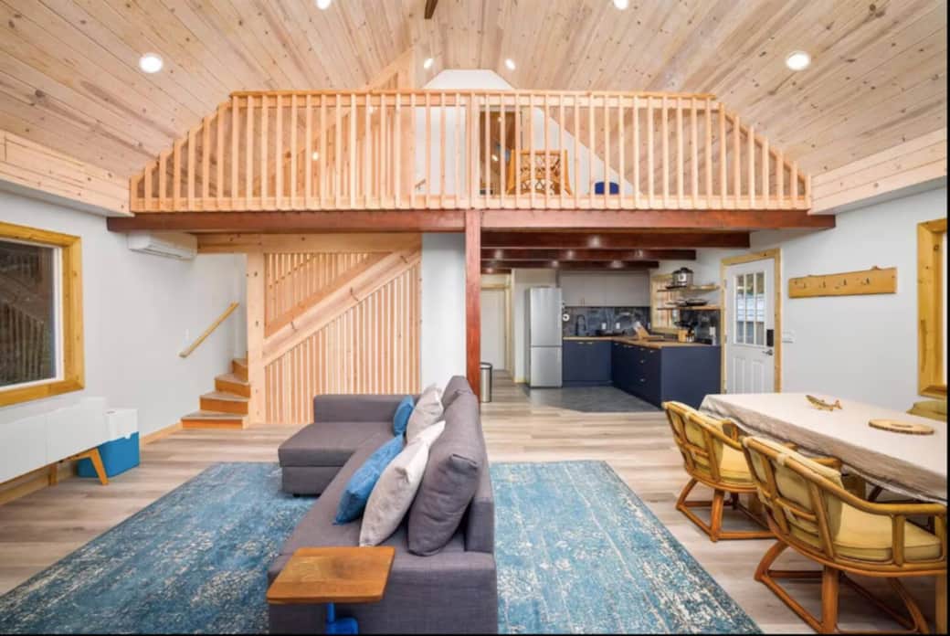 Open-concept living and dining area with vaulted wood ceilings and cozy loft—perfect for gathering and relaxing together.