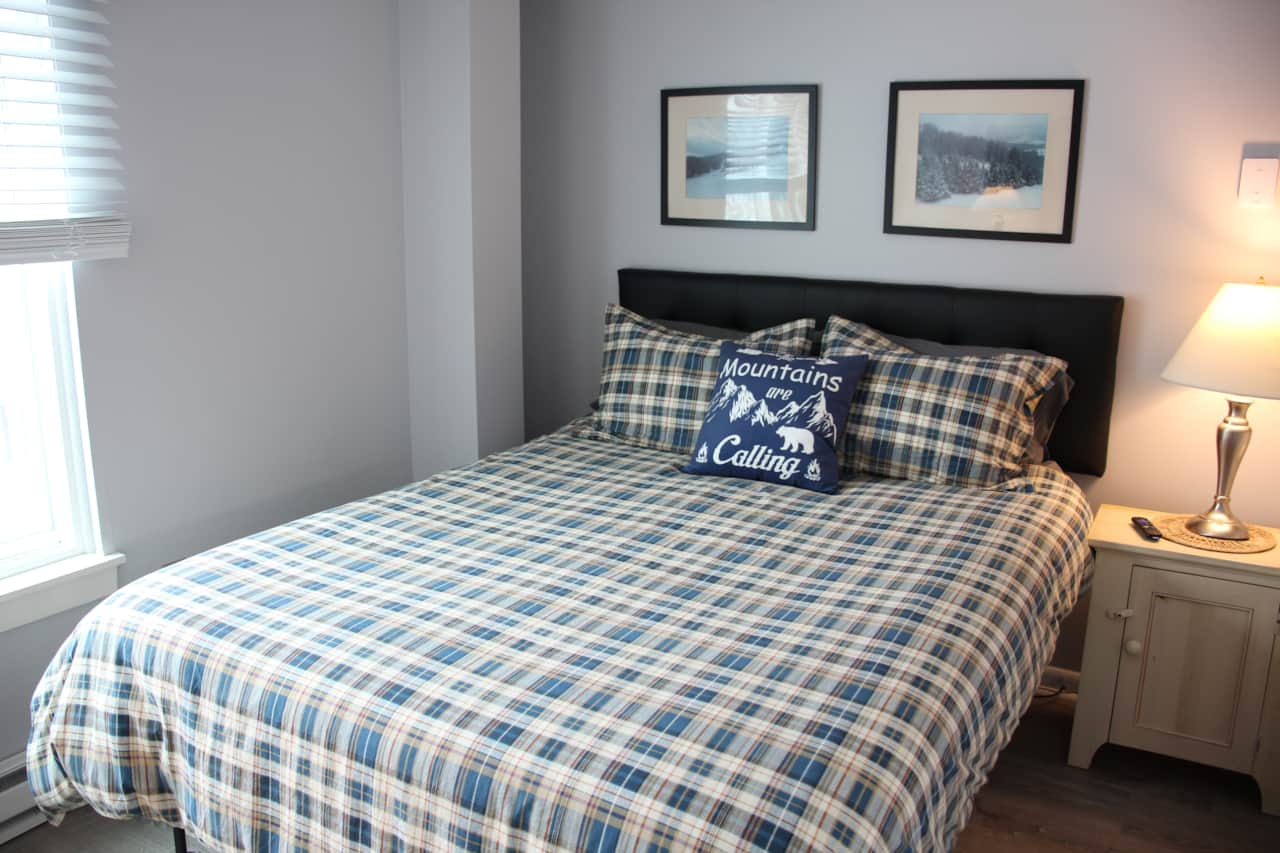 Bedroom features a comfortable queen bed , ample storage as well as a TV