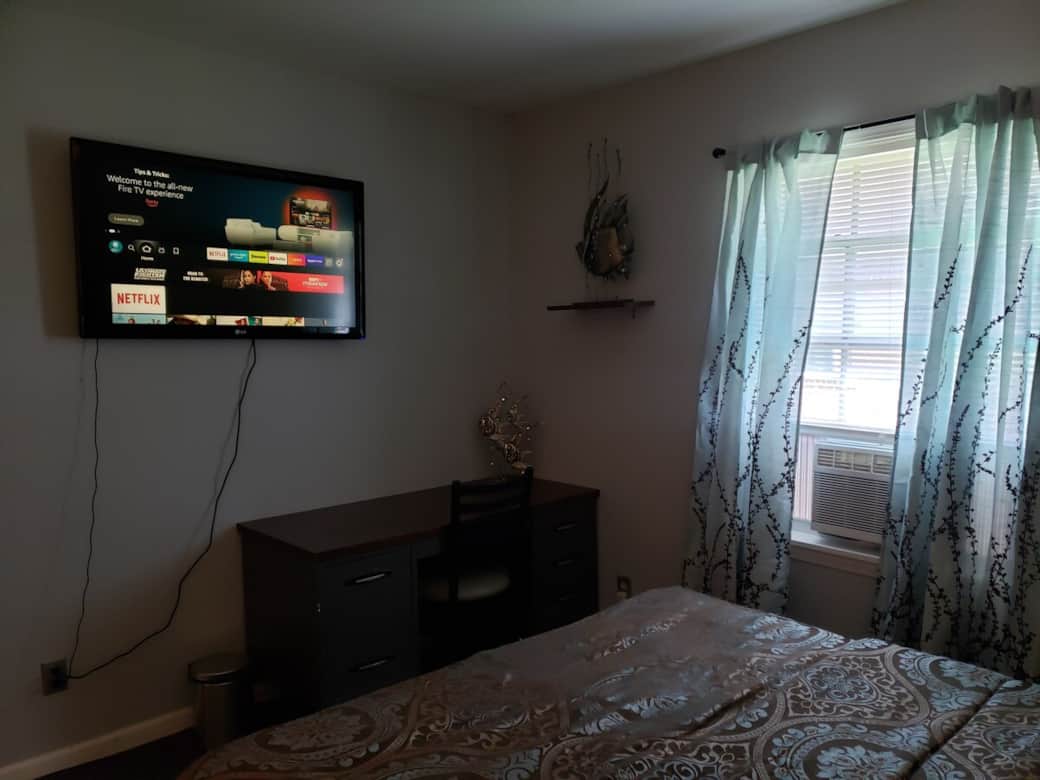 Bedroom 1, large work desk and TV. Window ac unit.