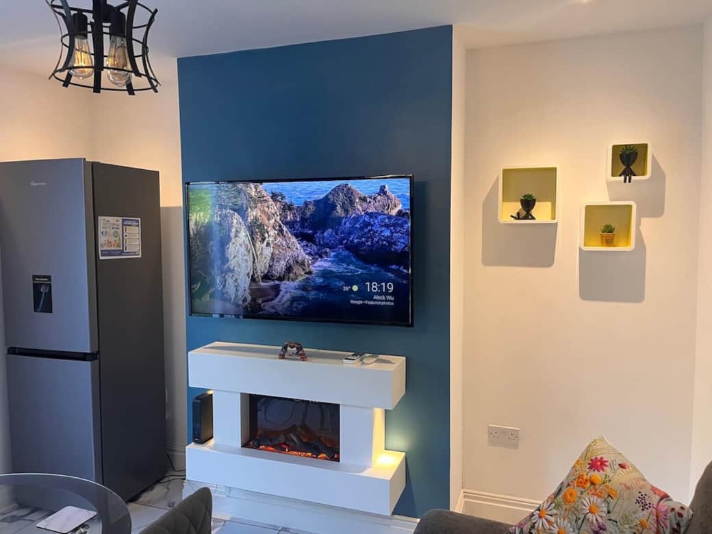55’ TV on swivel stand with underlying electric fireplace to create the perfect cozy, winter’s night cinema atmosphere 