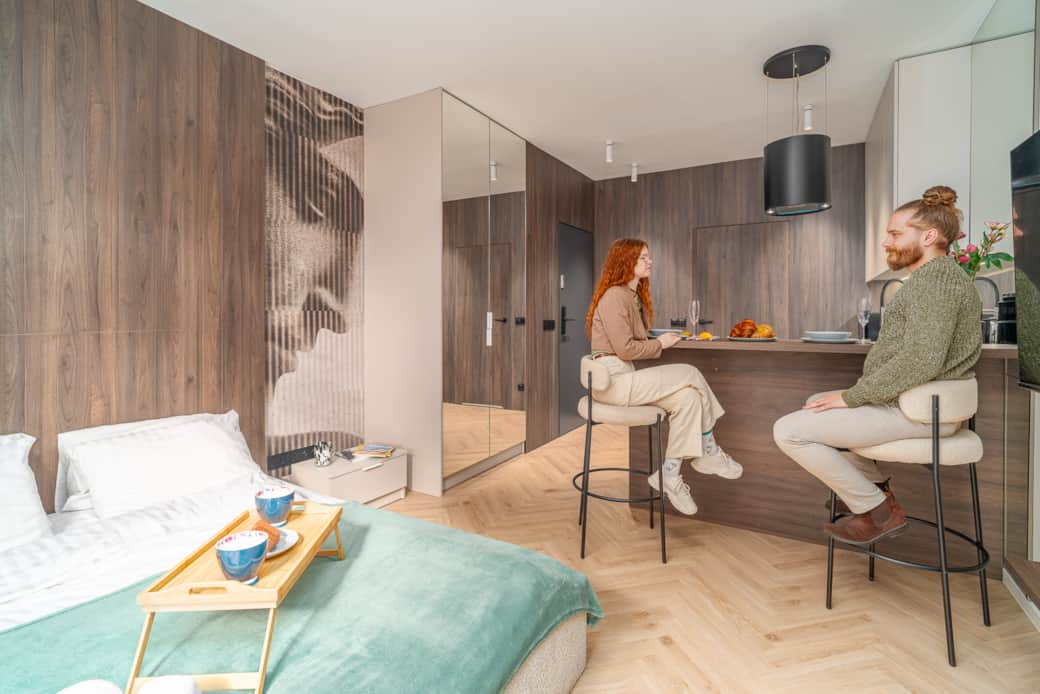 Jasne wnętrze z drewnianą podłogą i zabudową.