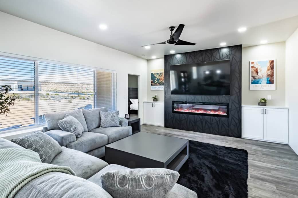 Unwind in the inviting living room, featuring an 85-inch TV for cinematic entertainment, a cozy electric fireplace, and ultra-soft plush sofas for ultimate comfort.