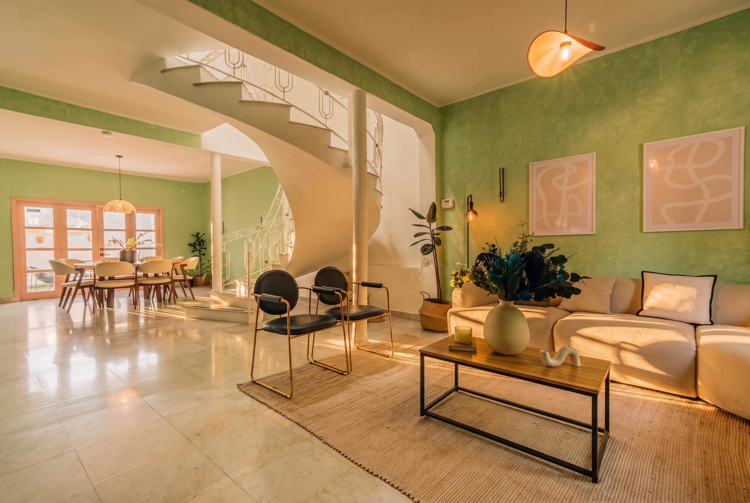 Open-plan living room with green walls, marble floors and the spiral staircase at Casa Atlixco