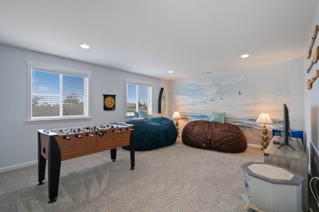 Fun-filled bonus game room with oversized beanbags and foosball - perfect for family game night.