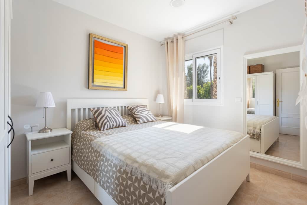 The second bedroom has a spacious closet and peaceful backyard views of lush lawns and two pools - p