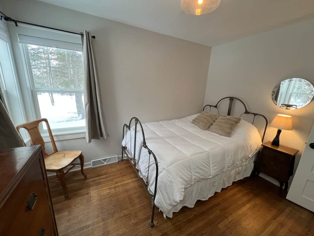 Main floor bedroom 2 with full bed, blackout and light filtering curtains and a 40" smart tv with di