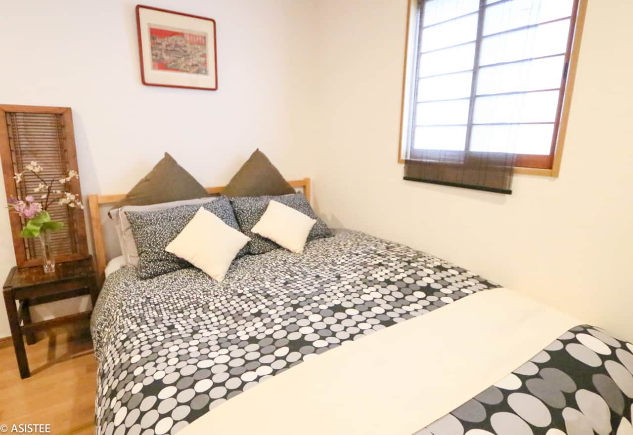 Relax in plush bedding surrounded by warm lighting and natural textures