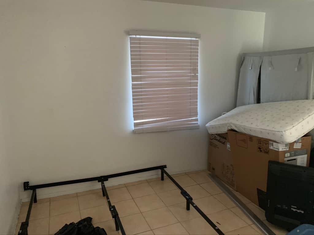 Original Unit 2 bedroom at Casa Citron showing a dark interior with tile flooring and no built-in closet before renovation.