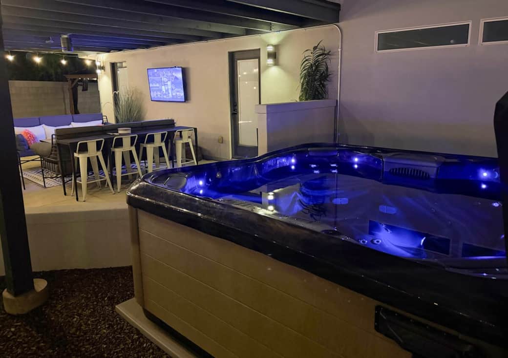Step directly from the primary suite to a comfortable patio seating area with a Samsung smart TV, just steps from the 8-person hot tub.