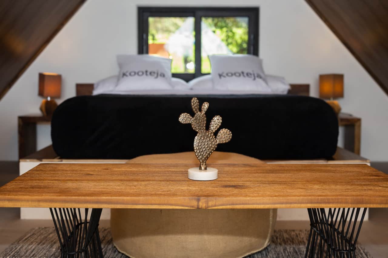 A stylish wooden coffee table and plush bed inside our tiny house Valle de Anton Panama.