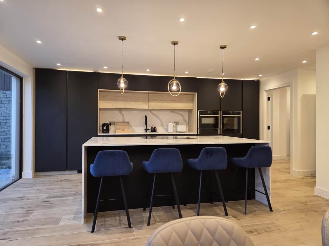 Entertain in this stunning designer kitchen, centred on a large island with blue velvet stools.