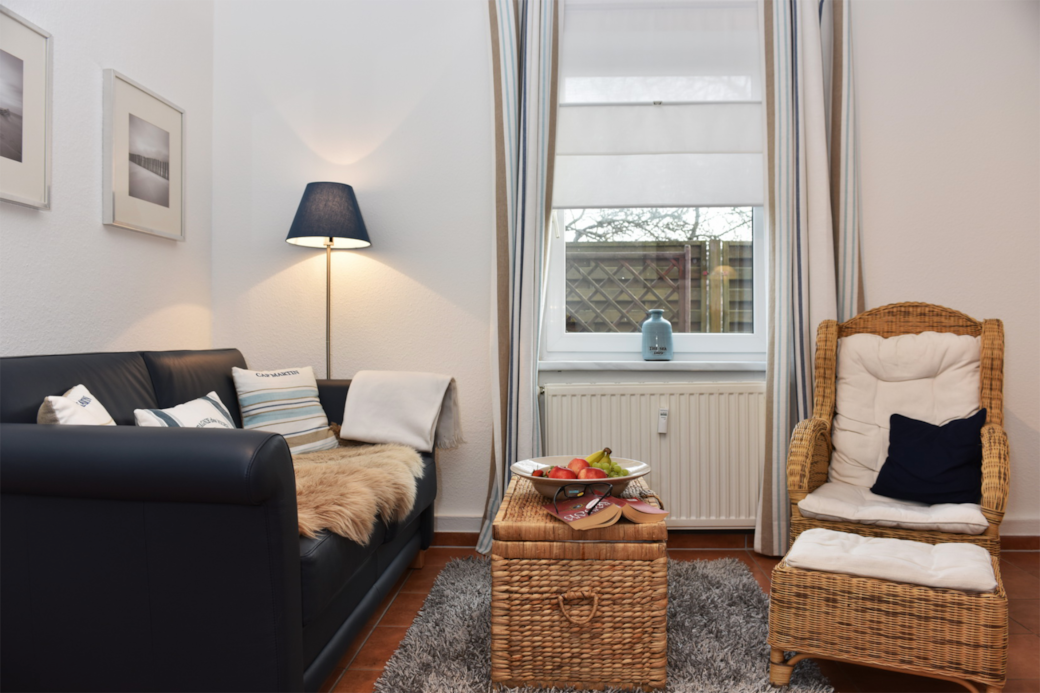 Gemütliche Sitzecke mit Couch und Stuhl am Fenster