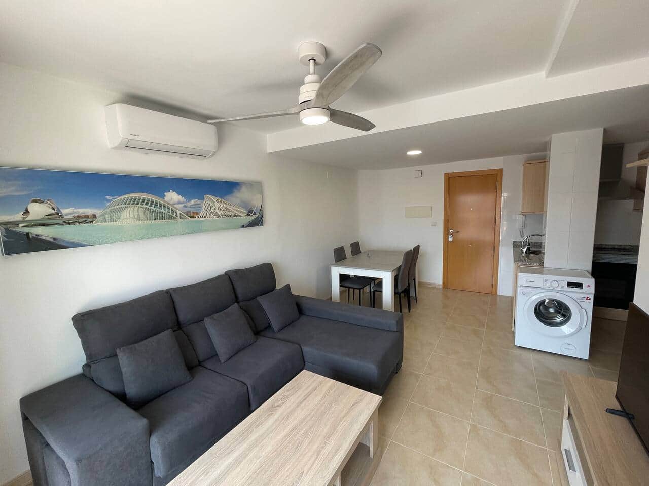 Salón con sofá, aire acondicionado y lavadora