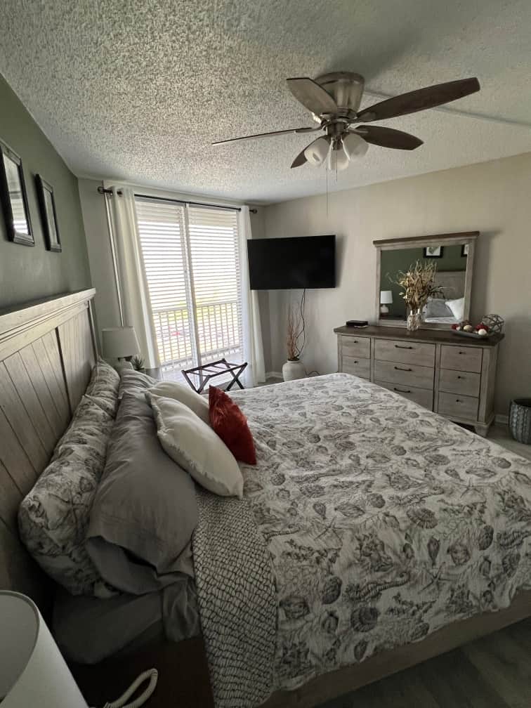 Guest bedroom – queen bed, tufted headboard and sliding glass doors
