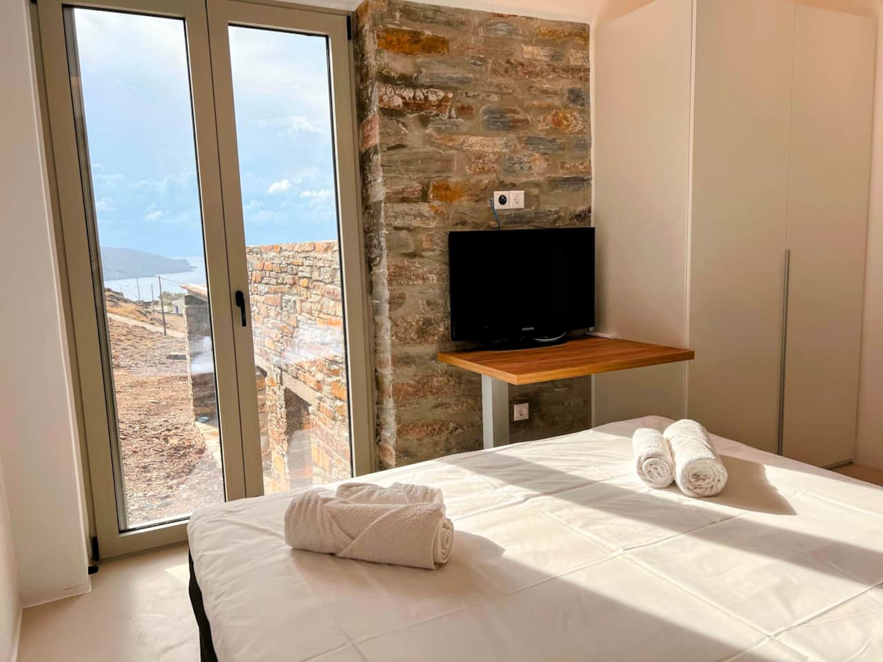 Bedroom with double bed, TV and a closet, stone holiday house, Kea