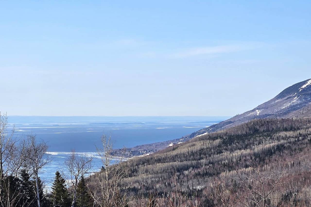 Vue sur le fleuve St-Laurent et le centre de ski Le Massif de Charlevoix. *** View of the St. Lawrence River and Le Massif de Charlevoix ski resort.