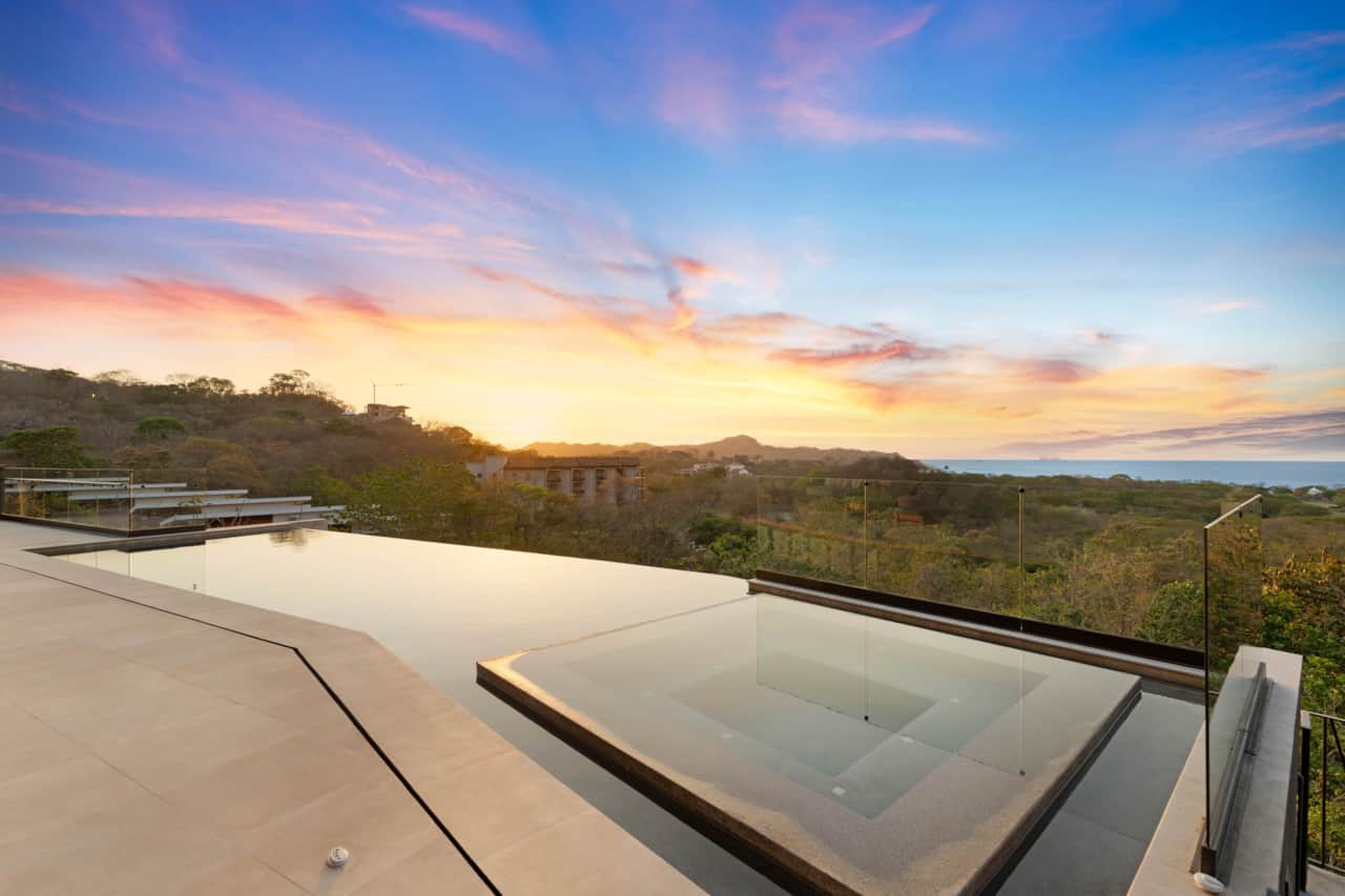 Infinity pool overlooking Playa Conchal at sunset