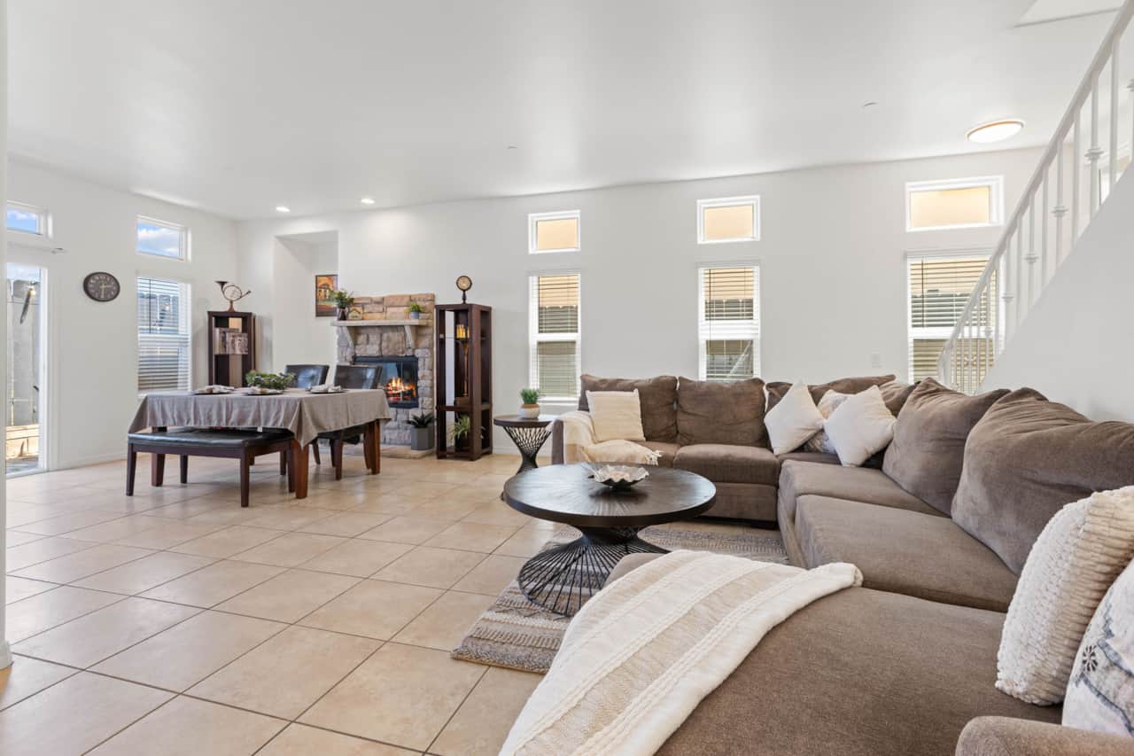 Spacious open-concept living room with plush sectional and fireplace ambiance.