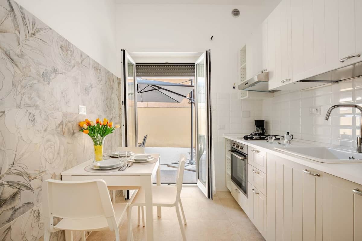 Cucina completamente attrezzata con tavolo da pranzo e accesso al terrazzo.