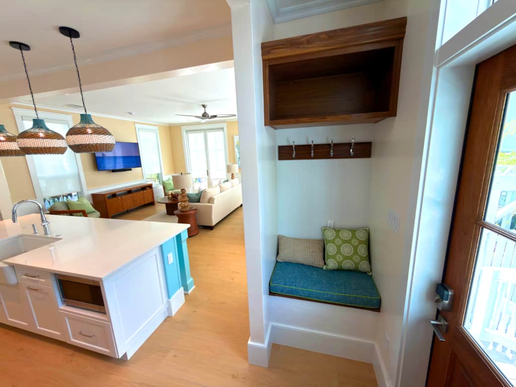 Entry nook with bench seating, coat hooks, upper shelf, and hidden storage below.