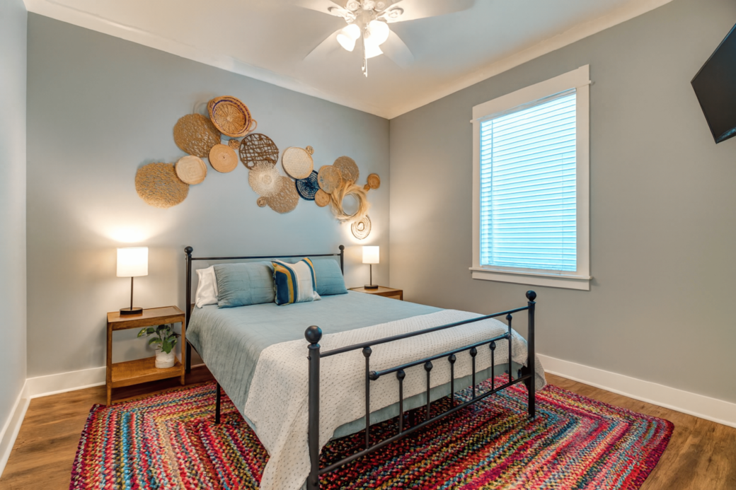 Cozy queen bedroom with streaming TV and boho decor.