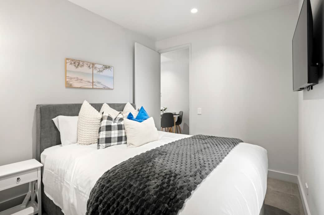 Bedroom 2 features a comfortable bed with soft linens and plush pillows, along with a Smart TV for your entertainment. Designed with a clean and modern layout, it offers a cosy and relaxing space to unwind.