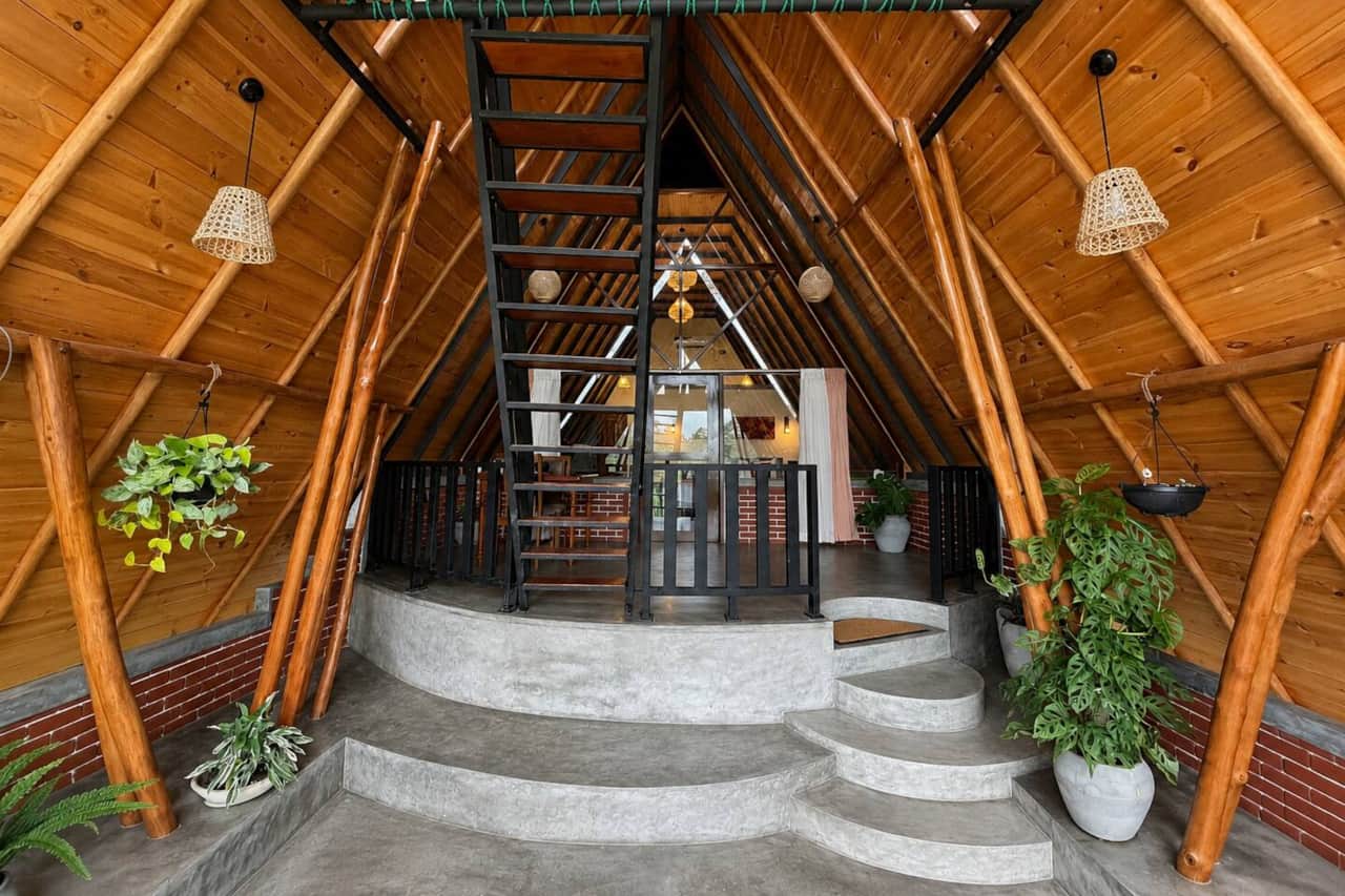 Warm timber, exposed A-frame lines and the central staircase create an open, distinctive space.