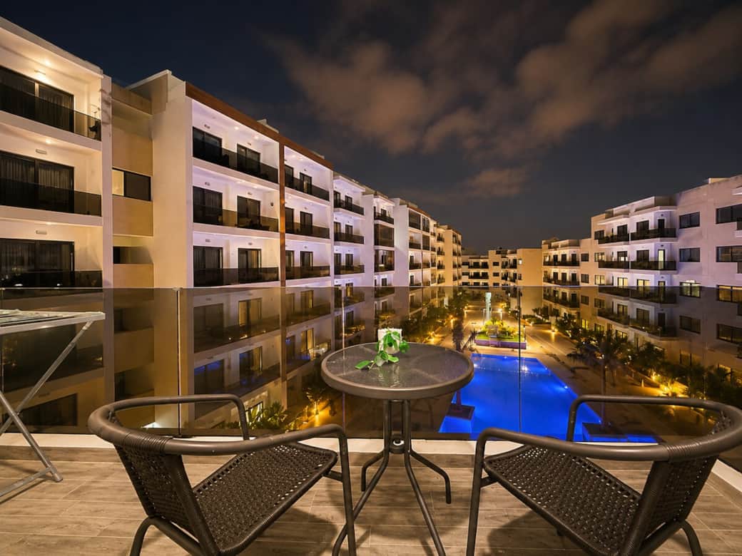 Private balcony with outdoor seating overlooking the illuminated pool and secure residence. The perfect spot to enjoy morning coffee or relax in the evening. Private balcony with outdoor seating overlooking the illuminated pool and secure residence. The perfect spot to enjoy morning coffee or relax in the evening.