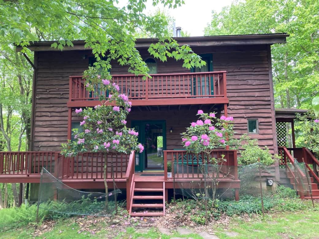 Front of cabin in the Spring. Flat Gravel parking spaces with the woods surrounding. Front and side doors. Front of cabin in the Spring. Flat Gravel parking spaces with the woods surrounding. Front and side doors.