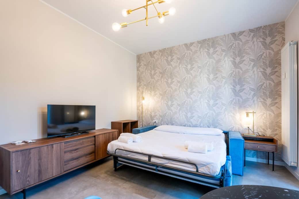 soggiorno accogliente con divano letto, tv e tavolo da pranzo
