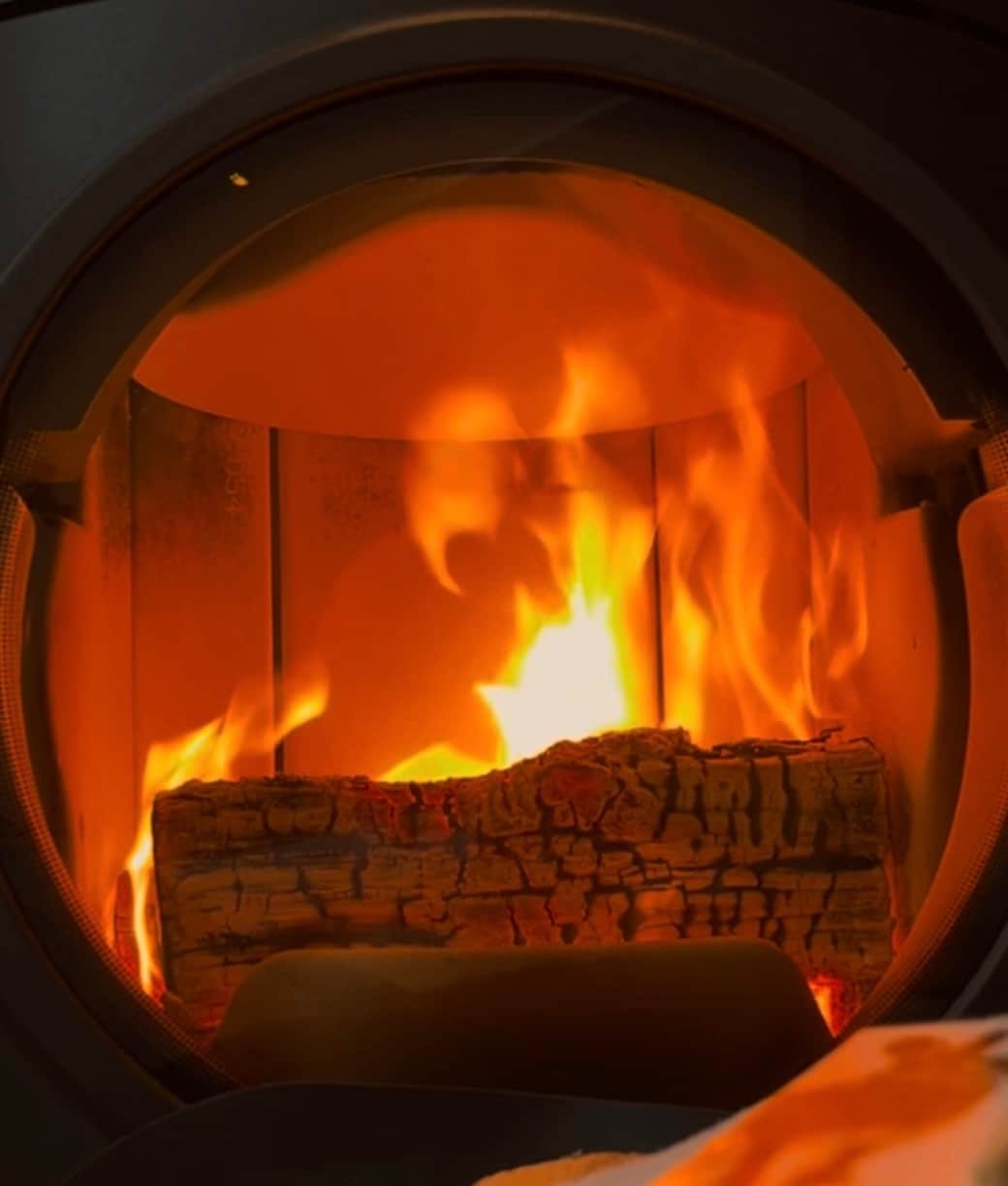 Flammenblick: Der Kamin knistert hinter Glas – Wärme, Ruhe und echtes Chalet-Gefühl.