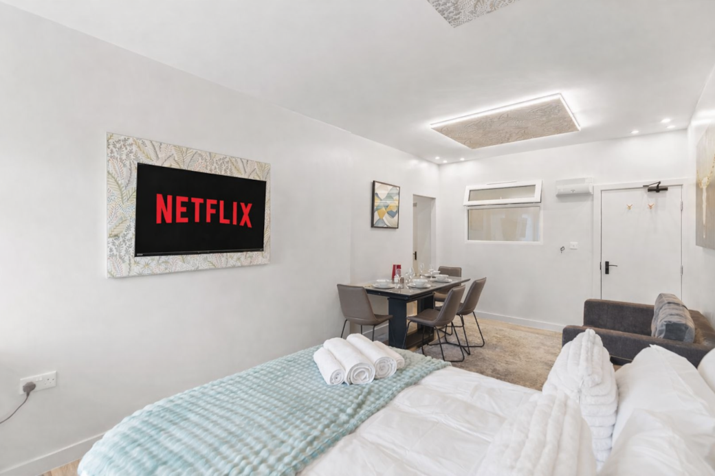 Bright and stylish bedroom featuring a plush double bed with luxury linens, feature wallpaper Bright and stylish bedroom featuring a plush double bed with luxury linens, feature wallpaper