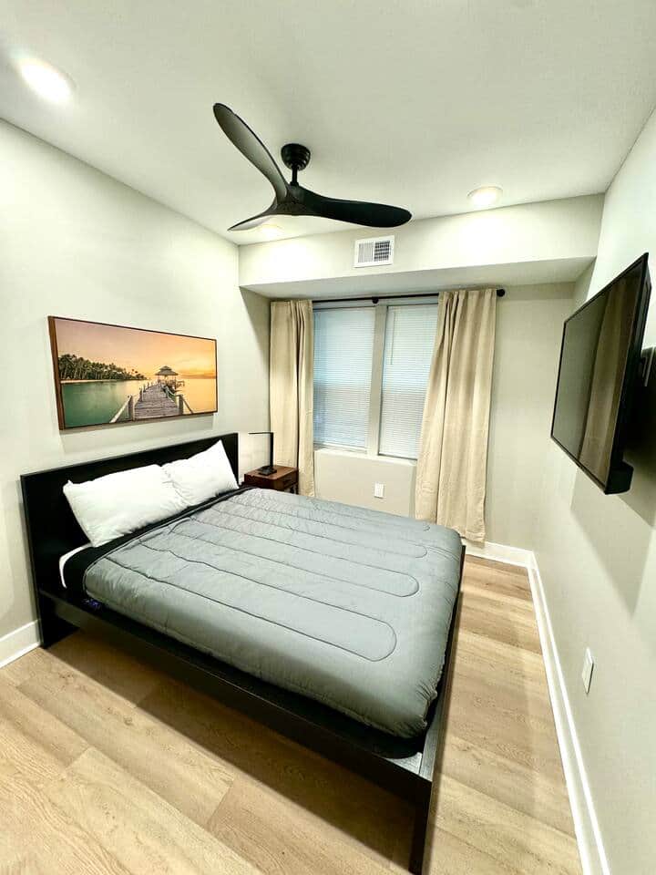 
Relax in our well-appointed bedroom, featuring a comfortable queen-sized bed and a convenient nightstand. Enjoy ample storage space with a large closet.
For entertainment, a flat-screen TV is provided, ensuring a pleasant and restful stay