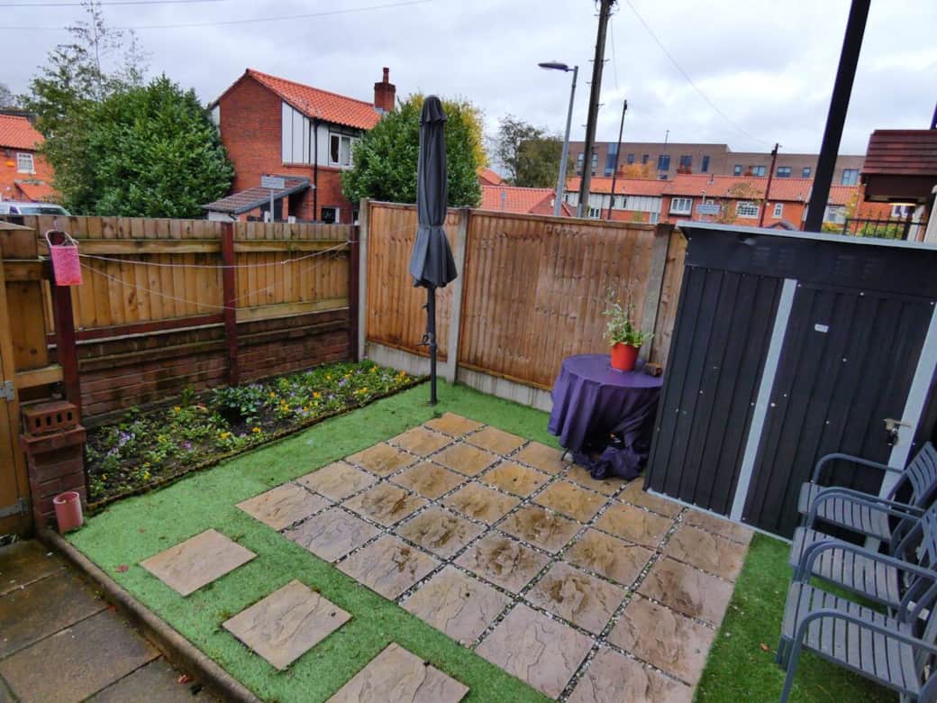 Private outdoor patio area at the front of the property, with garden furniture and parasol.