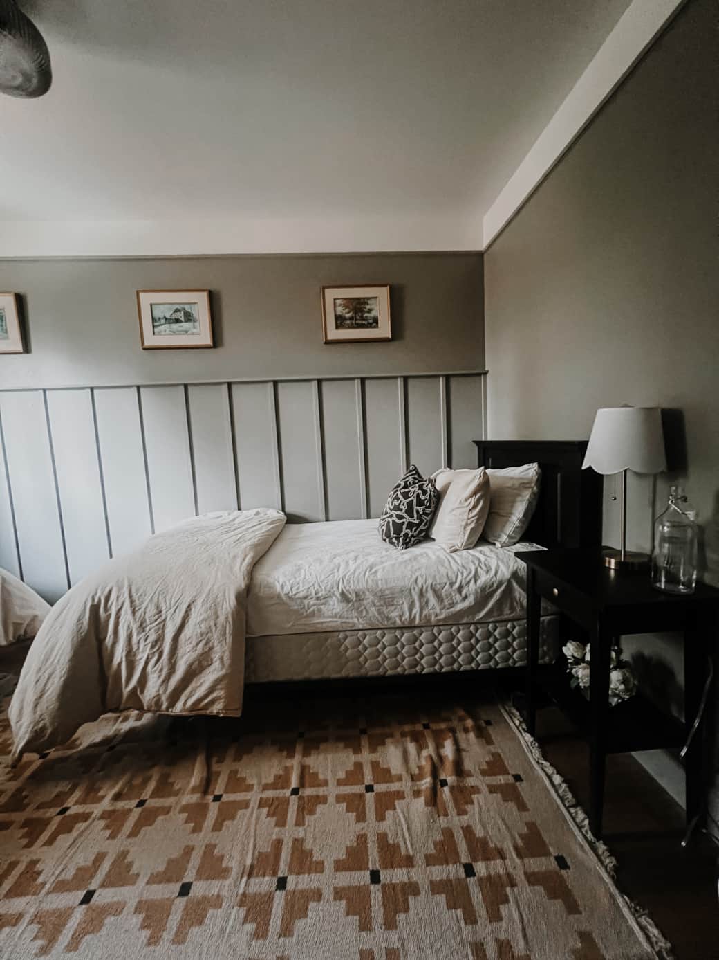 One of the cozy twin beds, with a bedside table and lamp (featuring a USB plug to charge devices.)