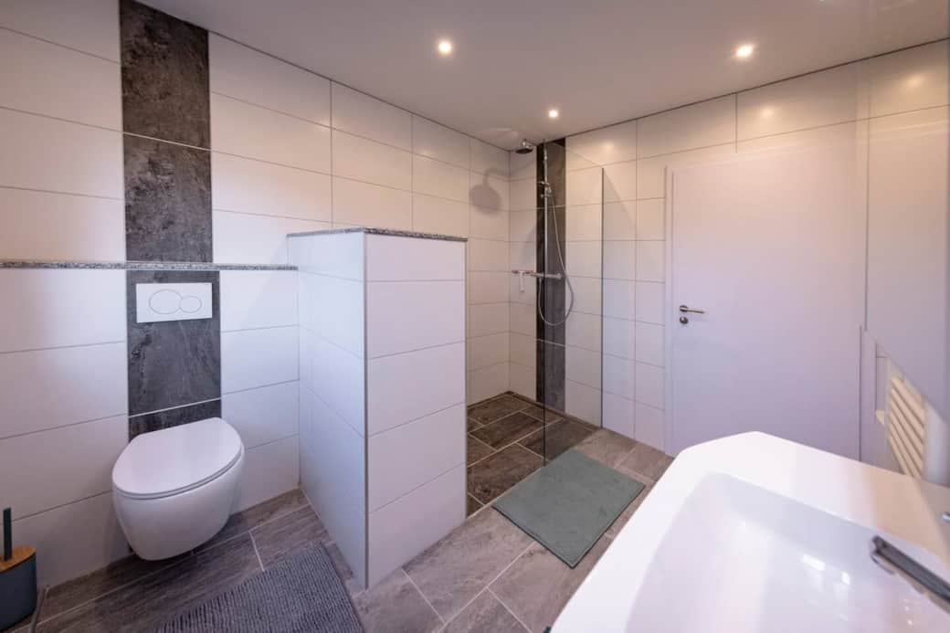 Der separierte Toilettenbereich fügt sich nahtlos in das helle, freundliche Badkonzept ein