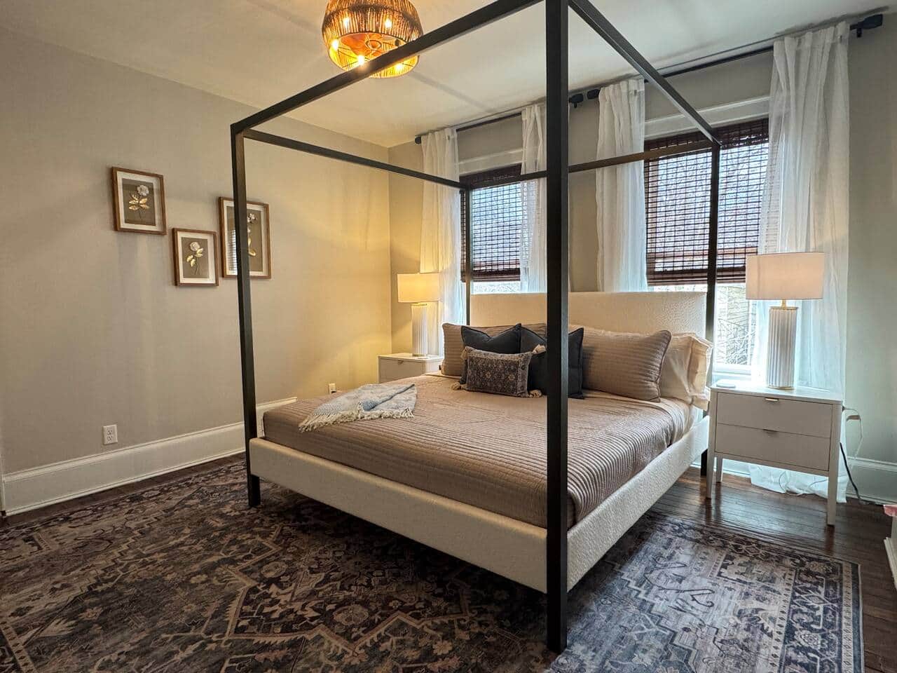 Stylish and serene bedroom featuring a modern canopy bed, soft neutral tones, and warm ambient light
