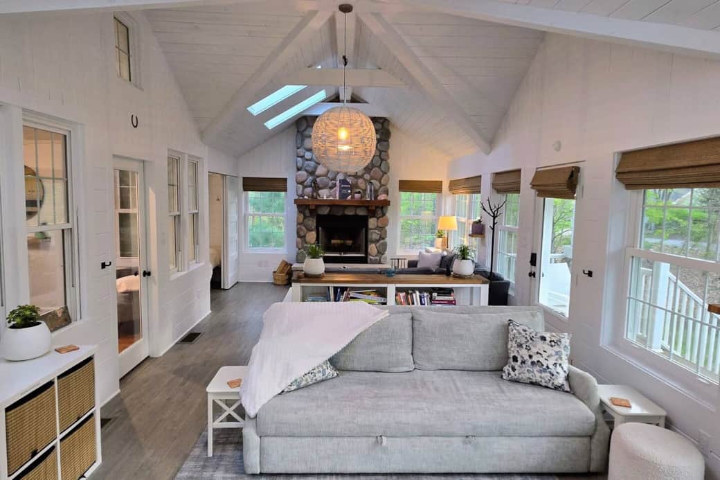 The living room features two seating areas: fireplace and television. The seafoam sofa is a queen-sized sleeper sofa.