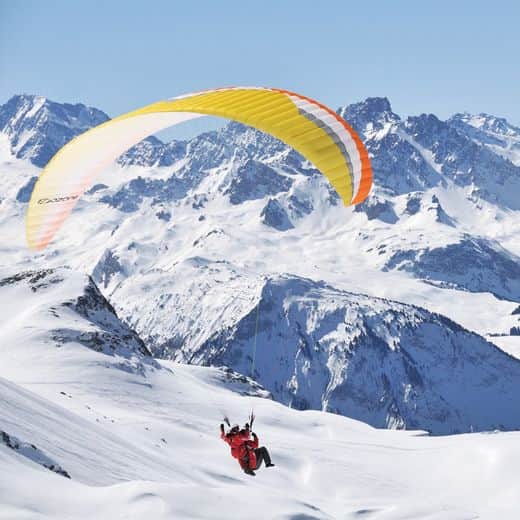 Baptême de parapente biplace au-dessus des sommets enneigés des Alpes, Serre Chevalier Vallée