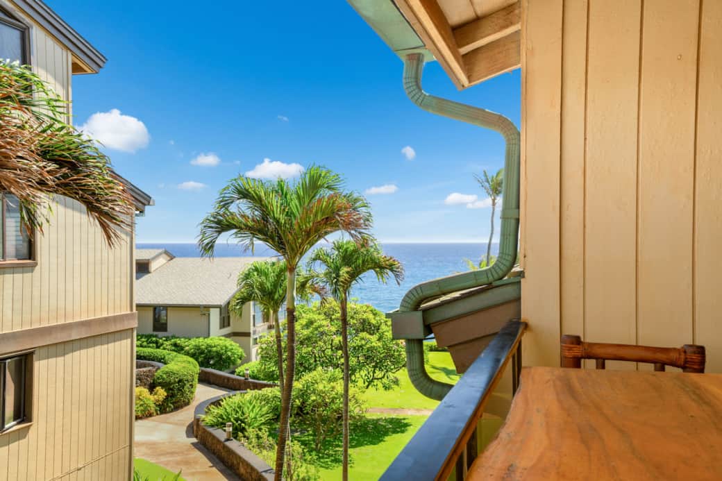 Lanai view of tropical grounds, palm trees, and a partial ocean view