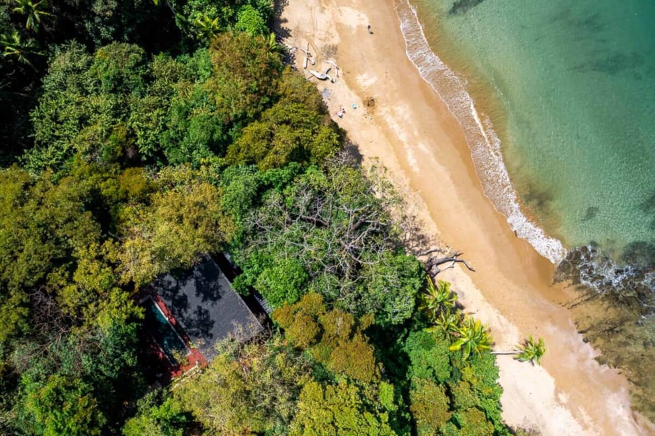 Aerial view of forest, sandy shore and turquoise water near Saboga Lodge, Pearl Islands