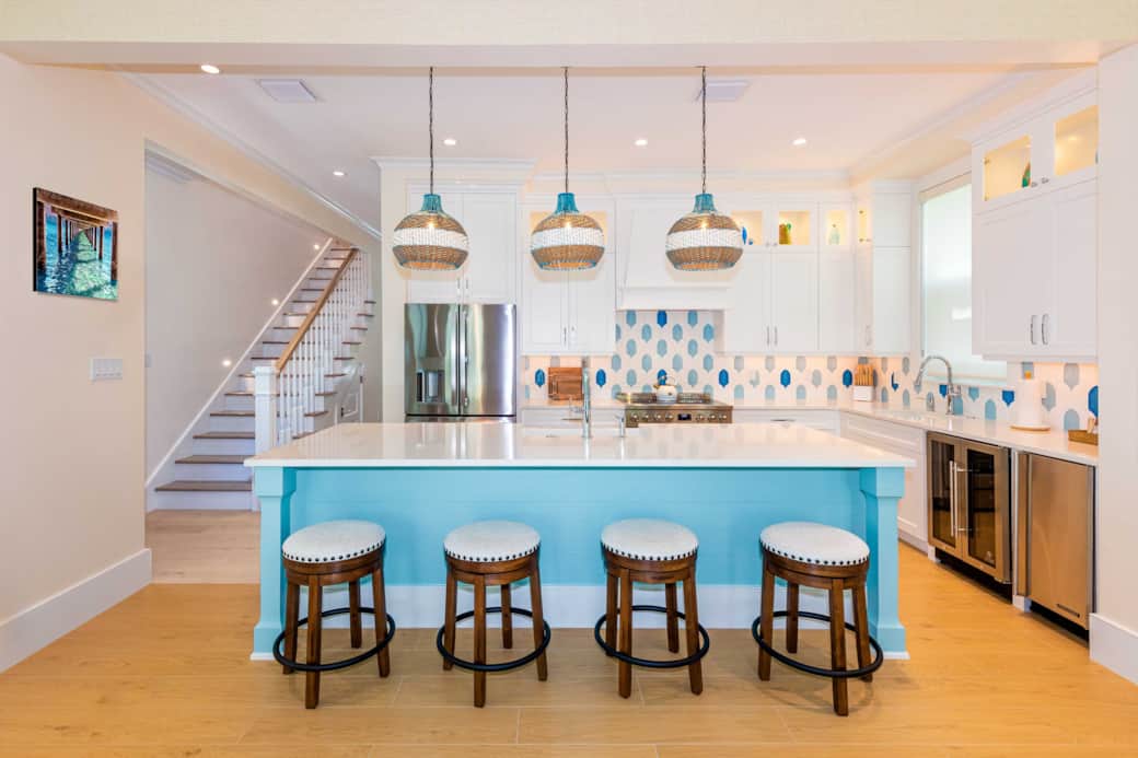 Open-concept kitchen with island seating, full appliances, and coastal-modern style.