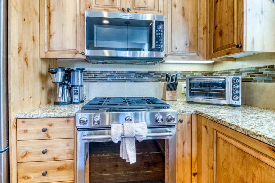 KitchenAid gas range, above-range microwave, and mosaic tile backsplash