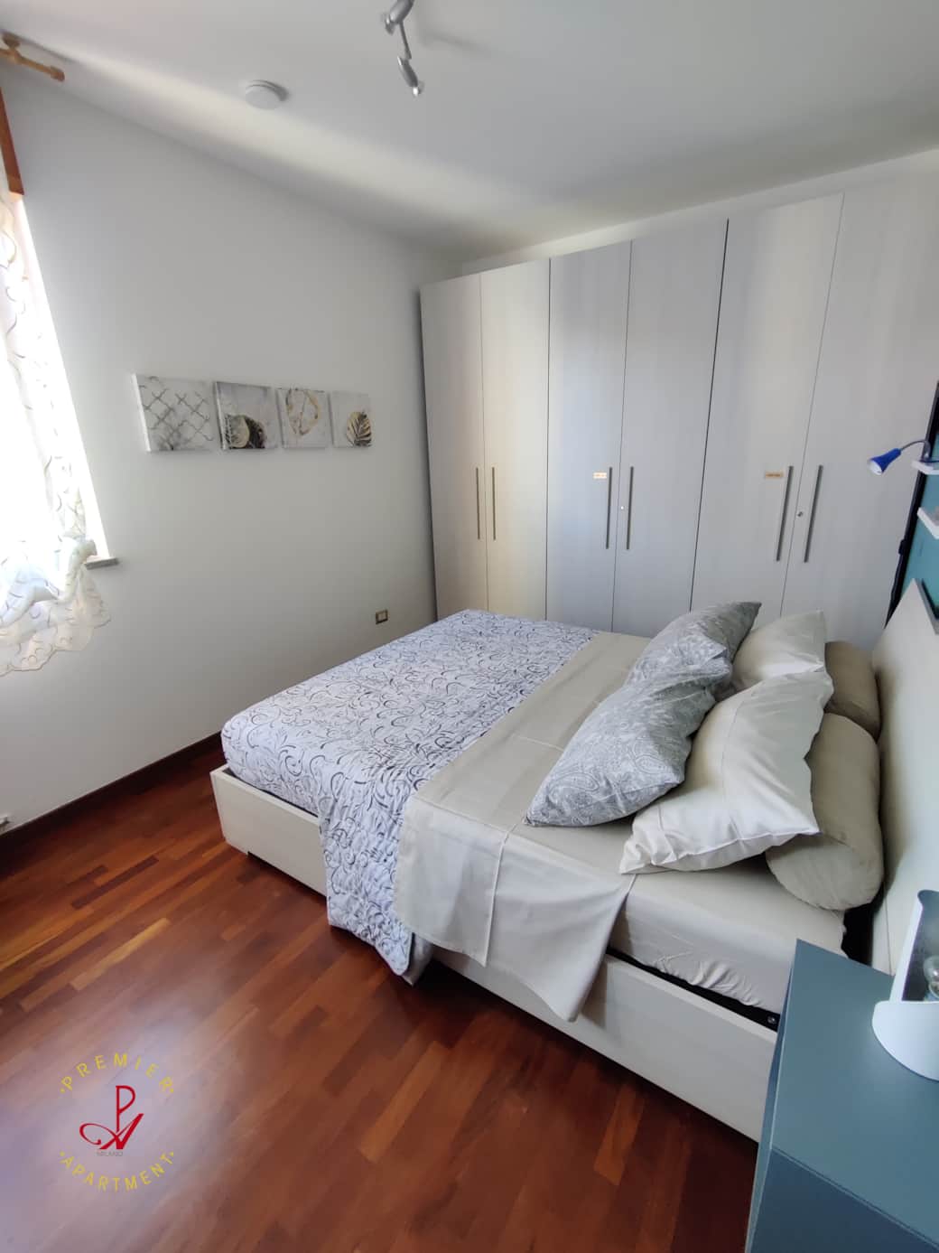 Bright bedroom with parquet flooring and wardrobe